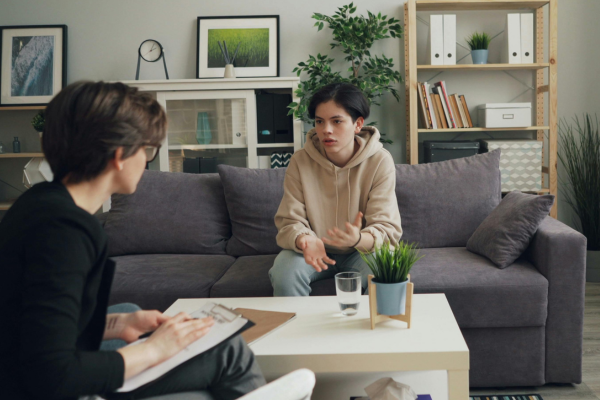 A non-binary individual in grief therapy session