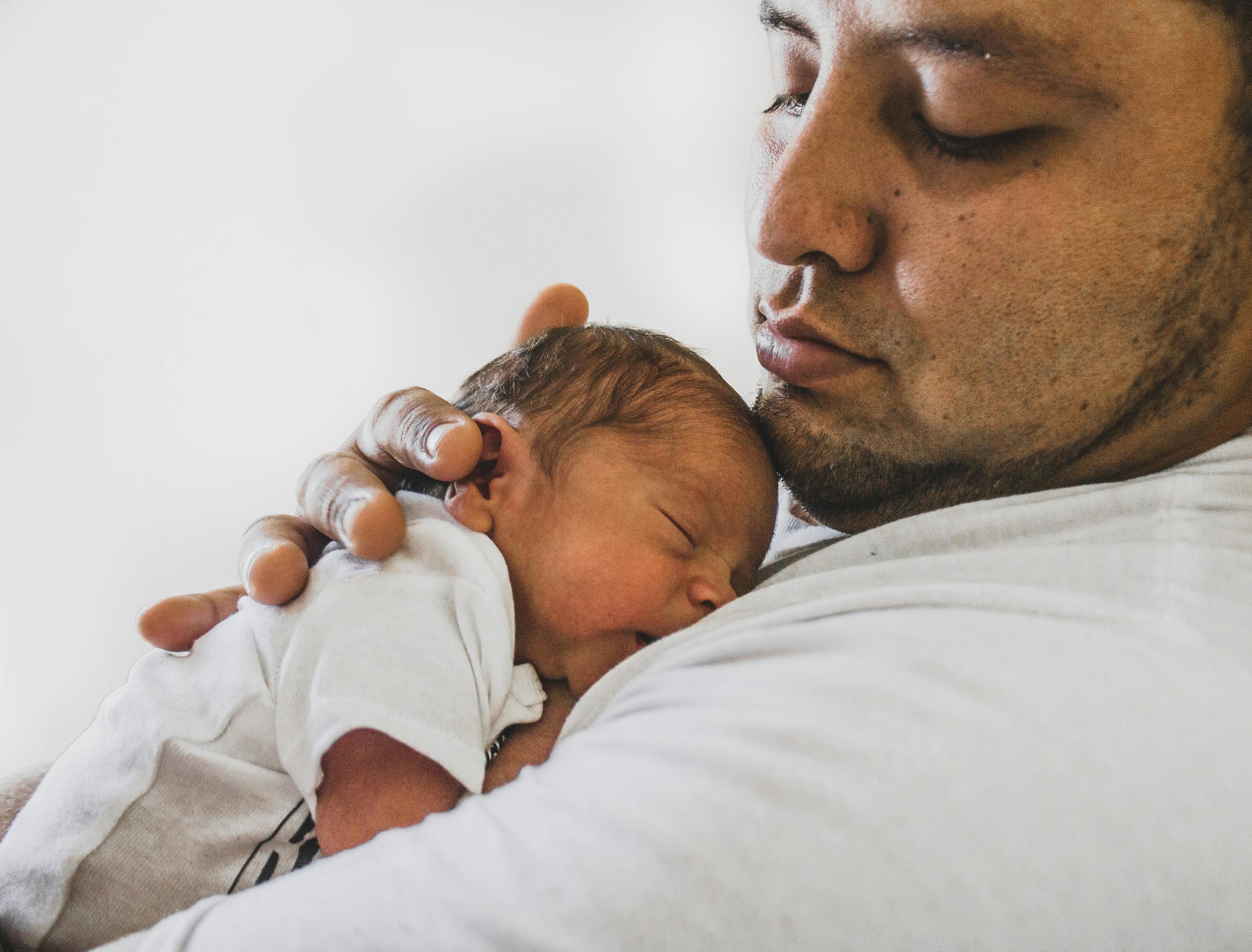 Father holding his newborn child, perinatal therapy in Edina, MN